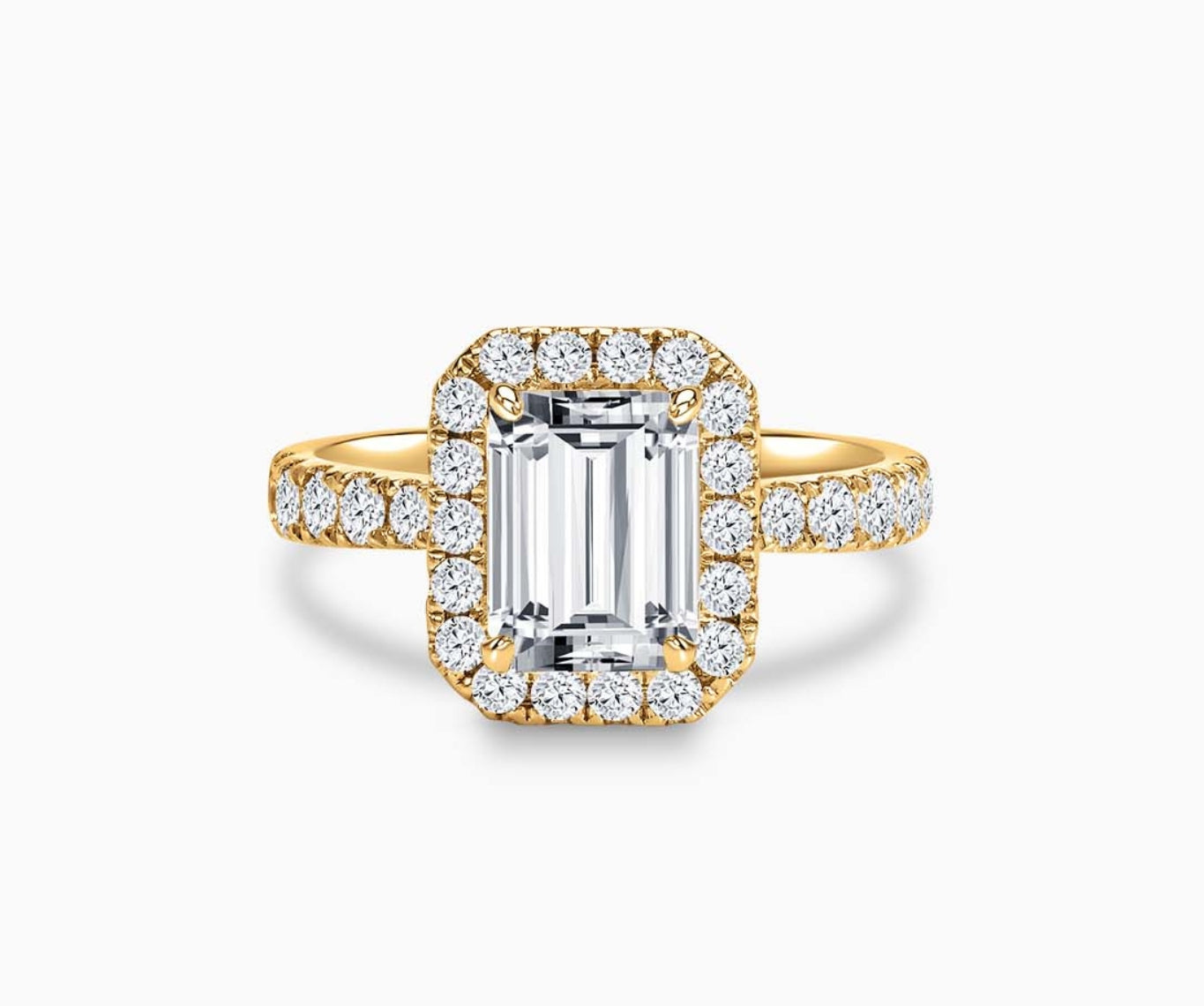 Emerald cut diamond halo engagement ring set on yellow gold with a tapered pave band design