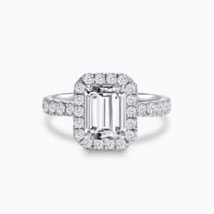 an engagement ring with emeral center stone and a halo setting design